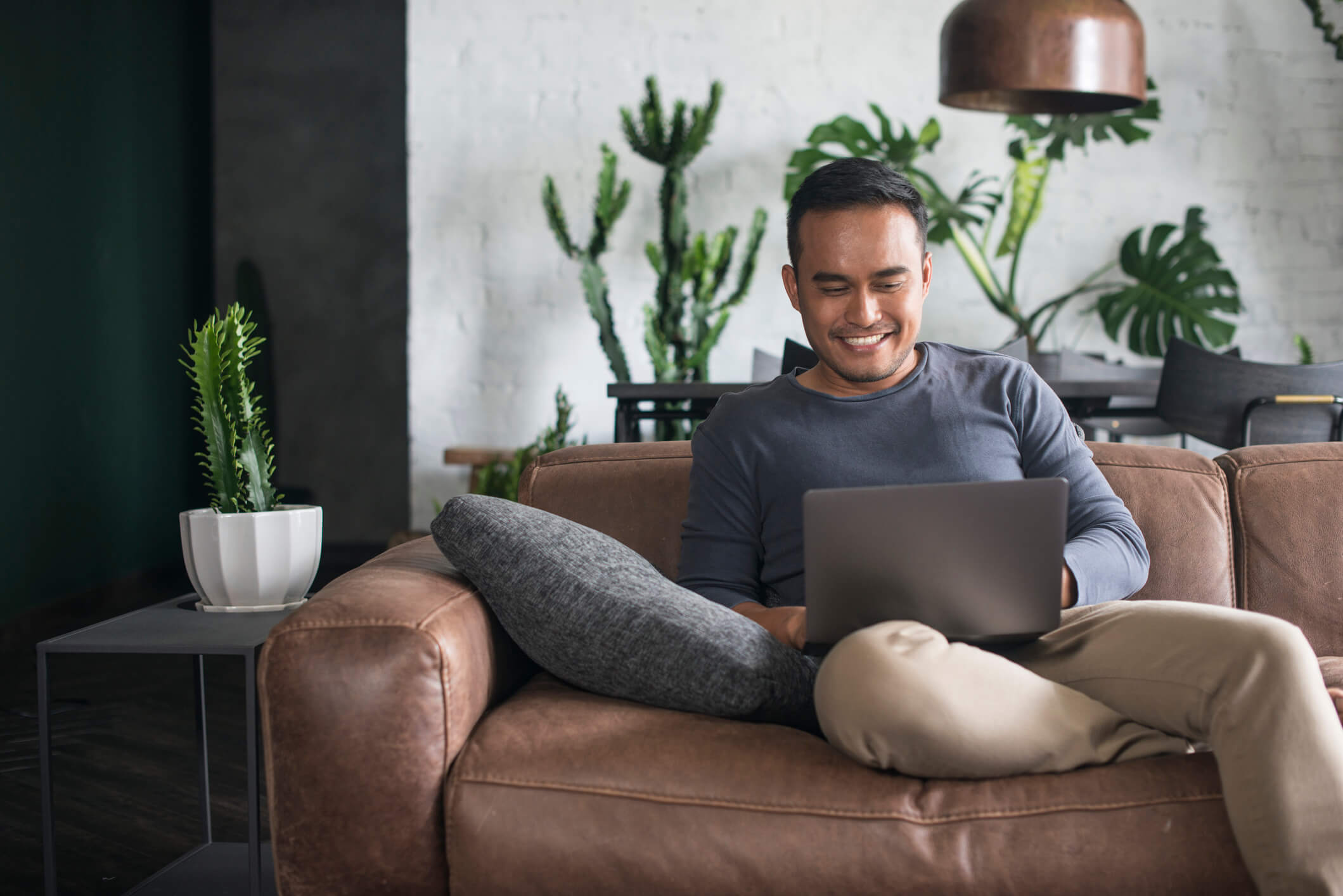 Young man looking for a mental health and wellness clinic on his laptop.