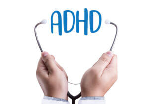 Image of ADHD text between a stethoscope representing the diagnosis of Attention Deficit Hyperactivity Disorder.