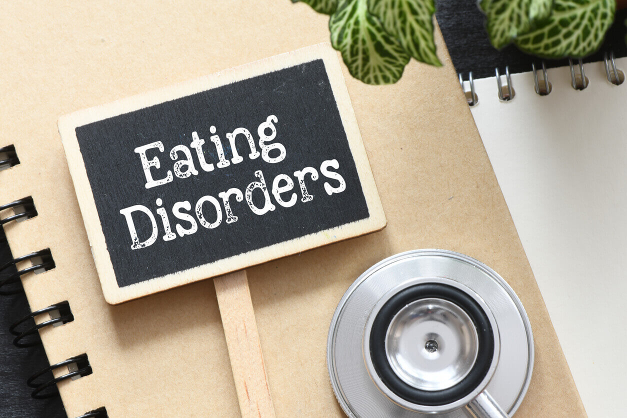 Eating Disorders words on a small chalkboard next to a stethoscope.