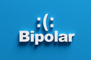 Bipolar disorder concept showing sad and happy moods.