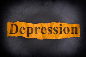 Torn crumpled piece of yellow paper with the word Depression